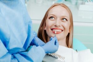 a woman patient smiling as her dentist gives her an exam