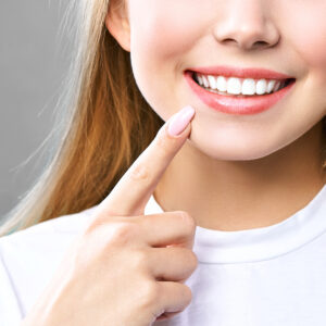 Woman pointing to her smile