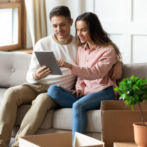 A couple sitting on a couch and reading an iPad